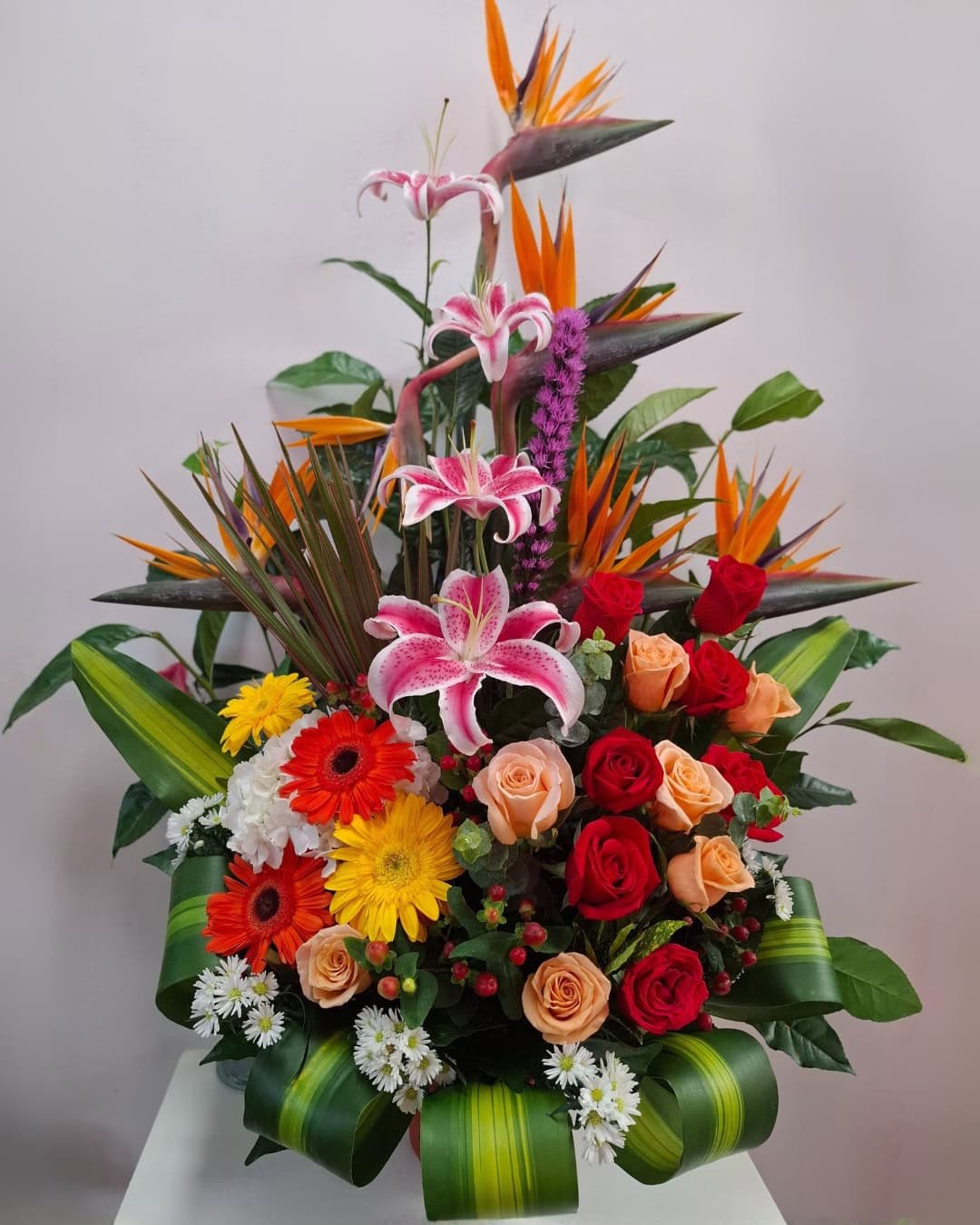 TROPIFUEGO – ARREGLO CON AVES DE PARAÍSO, LIRIOS ROSADOS Y ROSAS