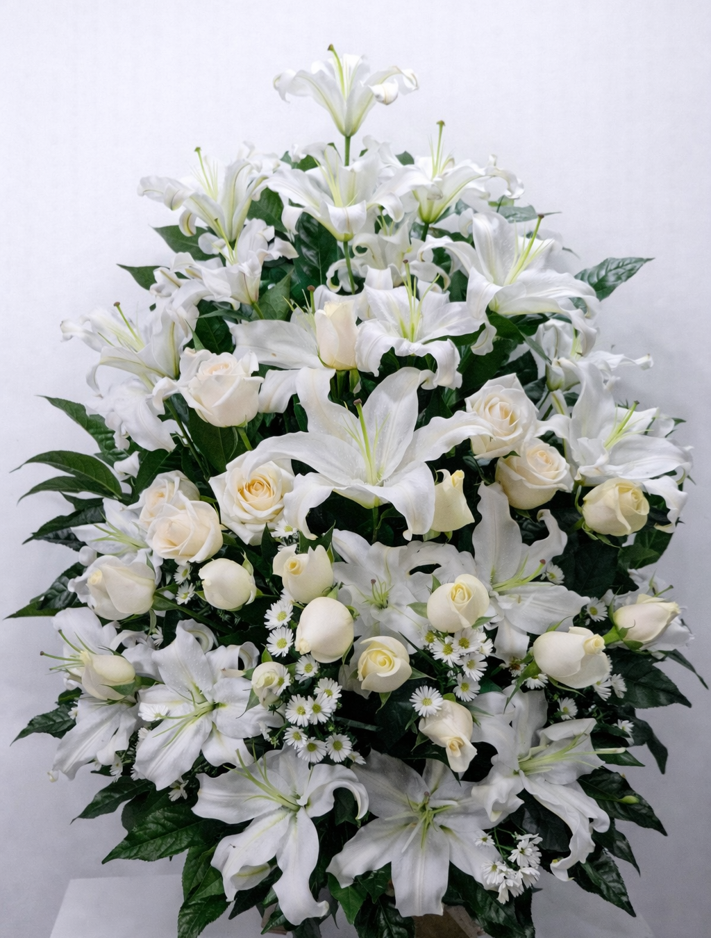 Paz Infinita – Arreglo fúnebre en cerámica de lirios blancos y rosas blancas con diseño abundante