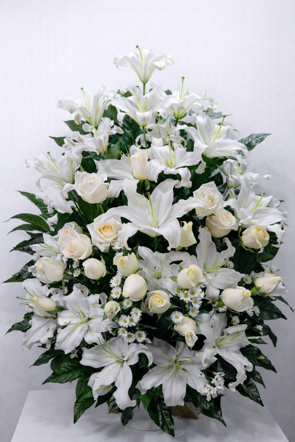 Paz Infinita – Arreglo fúnebre en cerámica de lirios blancos y rosas blancas con diseño abundante