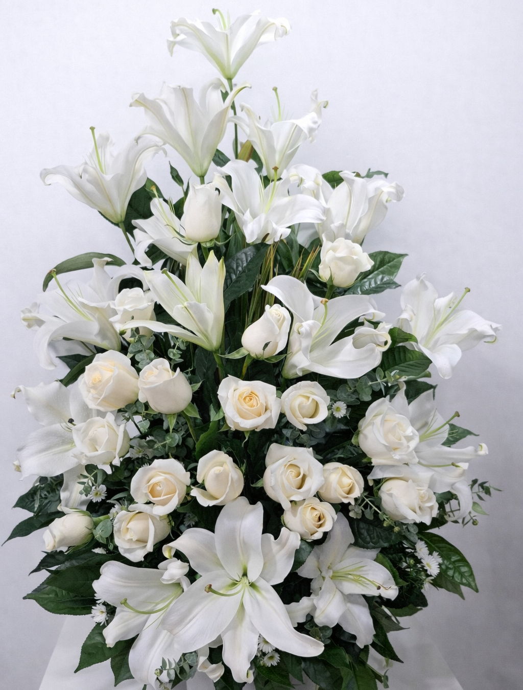 Alba Eterna – Arreglo fúnebre en cerámica de lirios blancos y rosas blancas con follaje premium