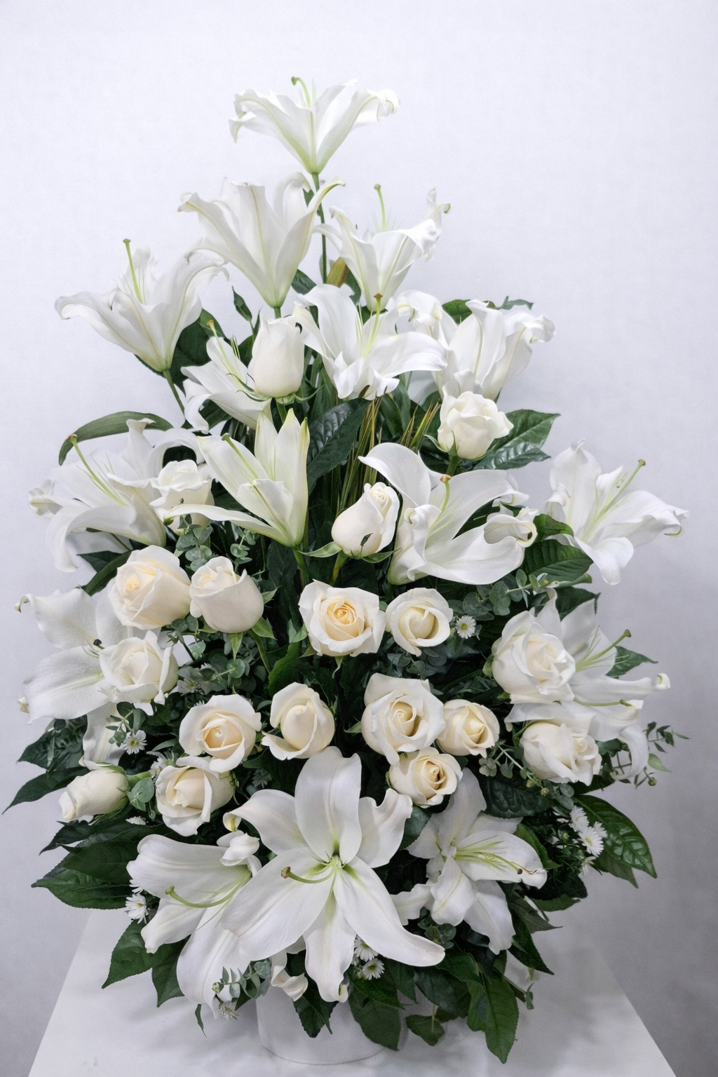 Alba Eterna – Arreglo fúnebre en cerámica de lirios blancos y rosas blancas con follaje premium