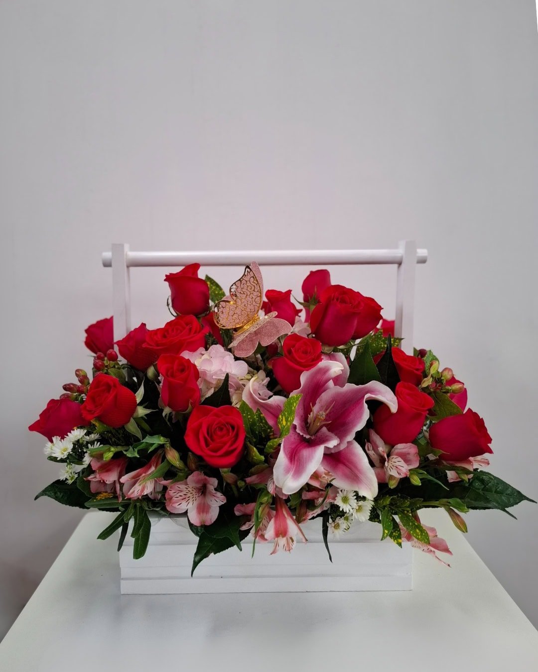 Mariposa Rubí – Arreglo en base de madera con rosas rojas y lirio rosado decorativo