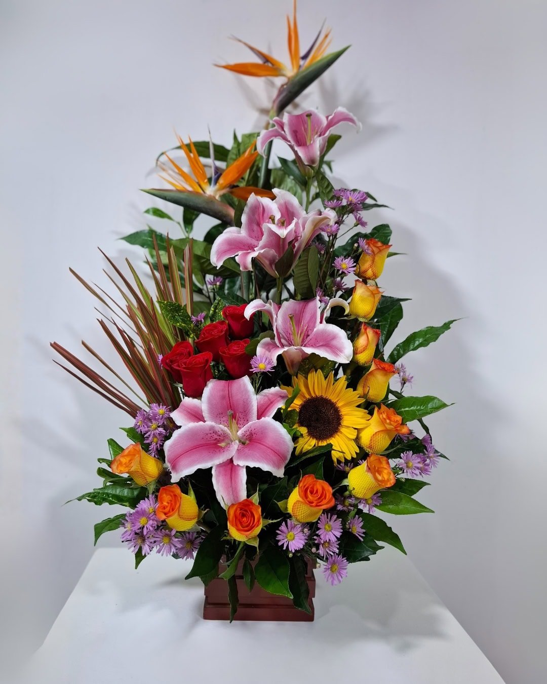 Fénix – Arreglo en base de madera con lirios rosados y diseño tropical