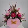 BMA-046-1 Mariposa Rosa – Arreglo en base de madera (corazón) con Gerberas fucsia y Rosas rosadas, estilo alegre