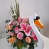 Cisne de Coral – Arreglo en base de madera (cisne) con Lirio rosado y Rosas pastel, detalle romántico