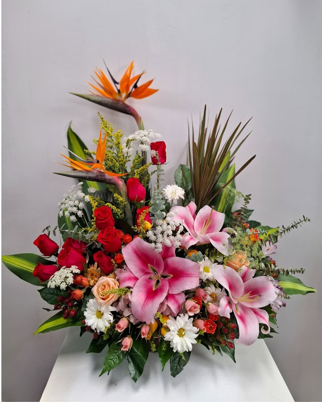 IMPERIO TROPICAL – CANASTA PREMIUM DE AVES DEL PARAÍSO CON LIRIOS, ROSAS Y MINIROSAS