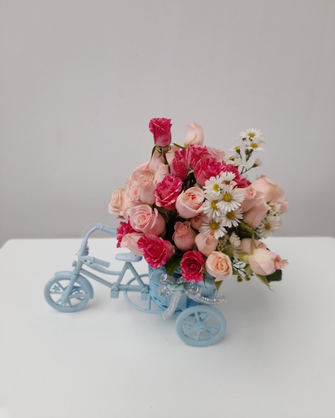 Celeste – Carreta de mini rosas durazno y fucsia con toque silvestre