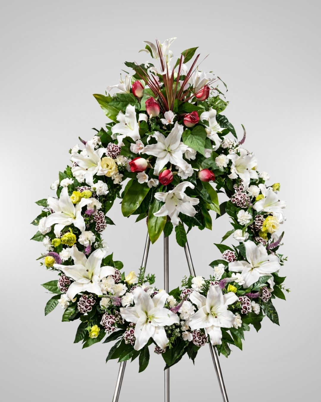 Eterno Abrazo – Corona Fúnebre en Trípode de Lirios Blancos con Rosas Rojas y Flores Mixtas