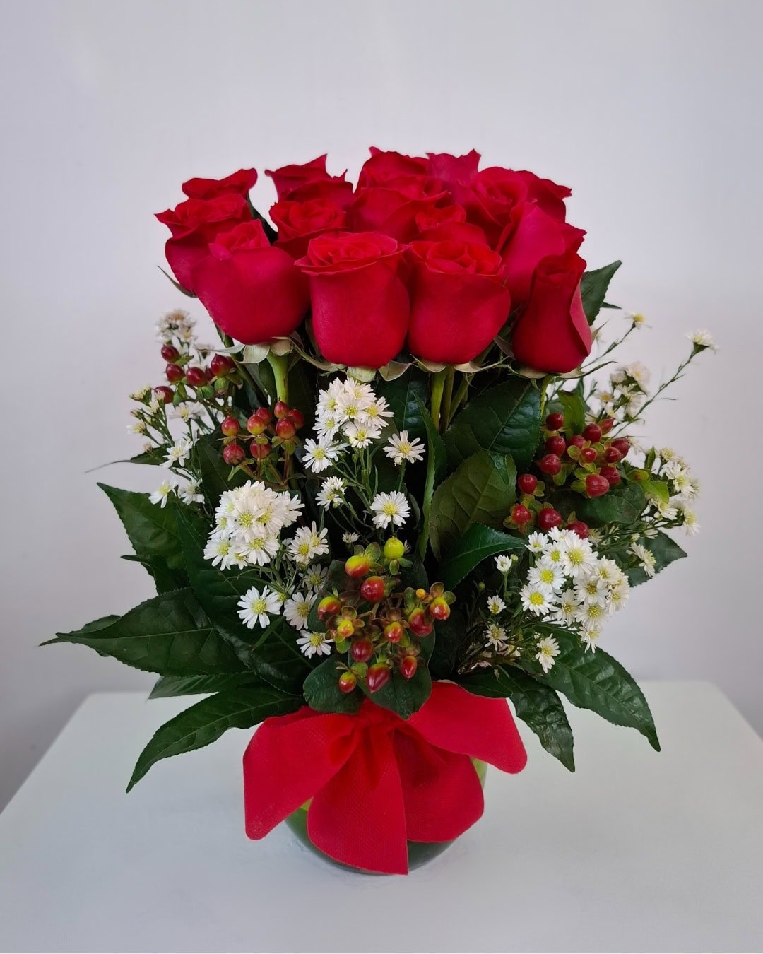 Rubí – Florero pecera de rosas rojas con acentos blancos y follaje premium
