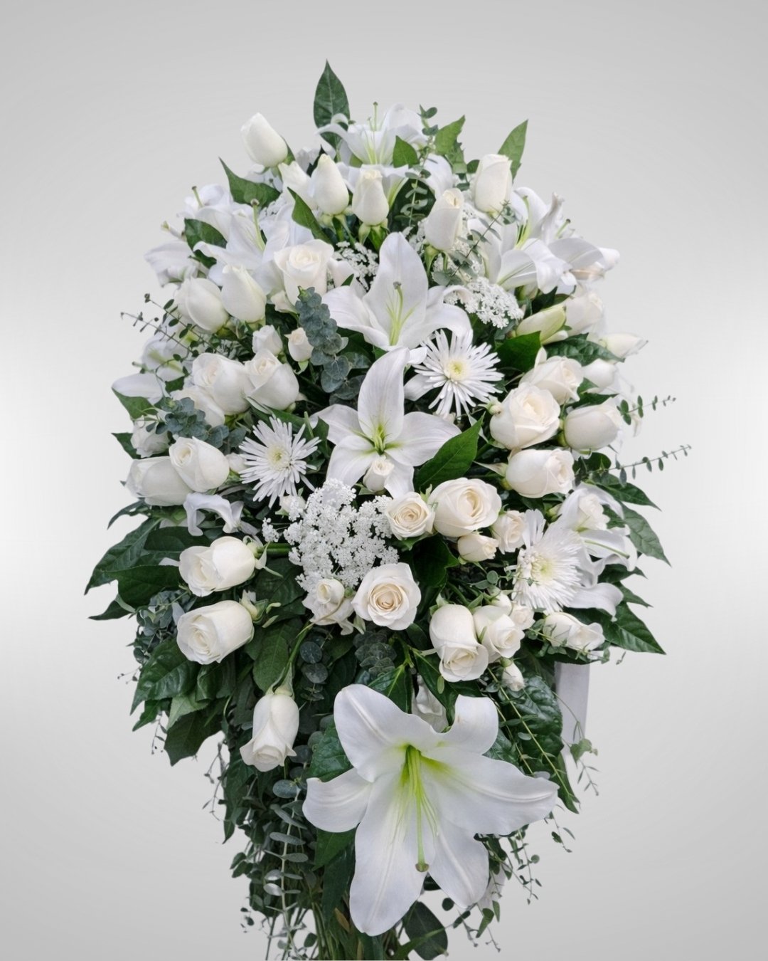 Nívea – Lágrima Fúnebre de Lirios Blancos y Rosas Marfil con Follaje Eucalipto