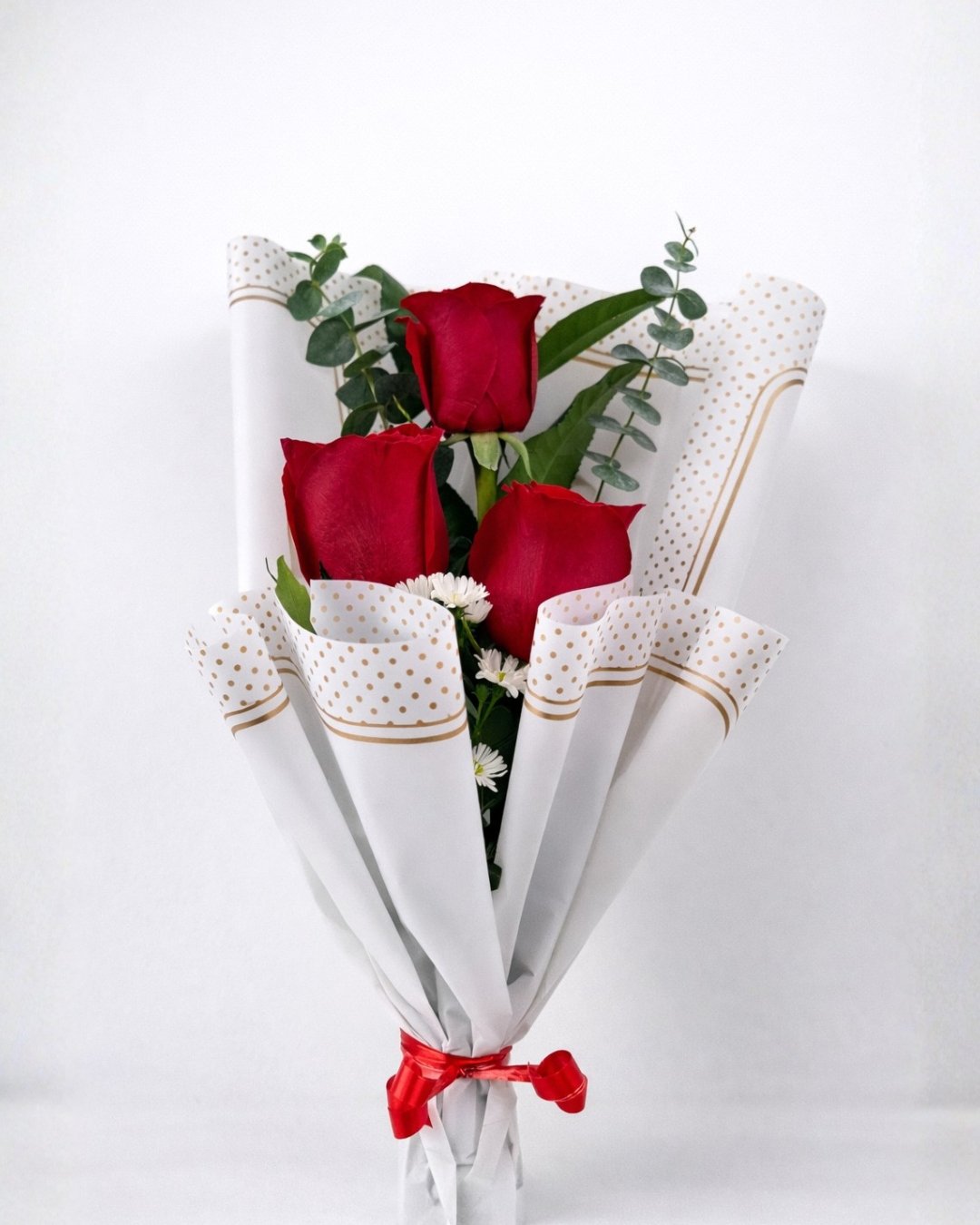 Trío Rubí – Ramo floral de 3 rosas rojas con eucalipto, acentos blancos y envoltura elegante