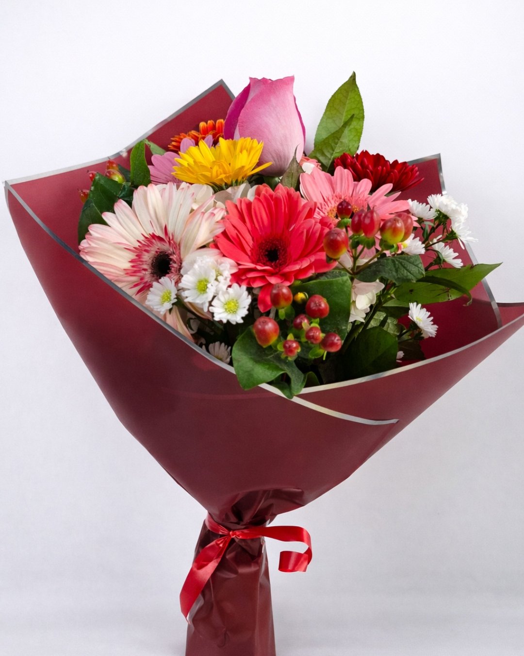 RAM-073 Solaria Mix – Ramo floral con rosa rosada, gerberas multicolor, berries rojas y follaje vibrante